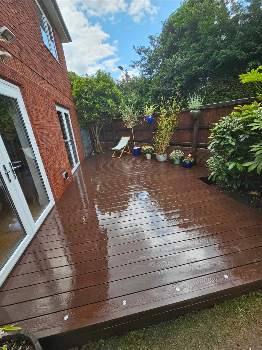 Dark composite deck with inset lights running along the rear of a house
