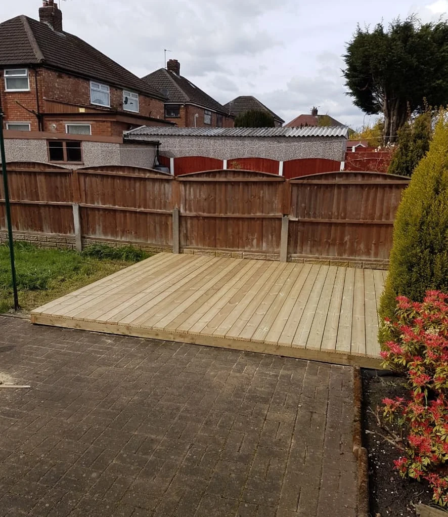 Timber deck built onto the corner of a garden beside existing paving