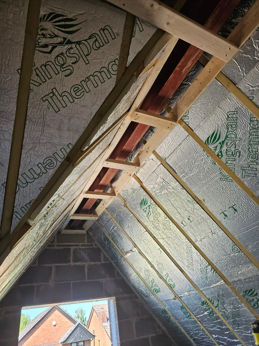 Vaulted roof space with new timber framing and rigid insulation boards fitted between the rafters
