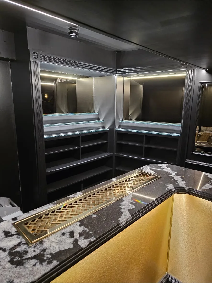 Mirrored back bar with lit glass shelving and dark timber storage shelving beneath