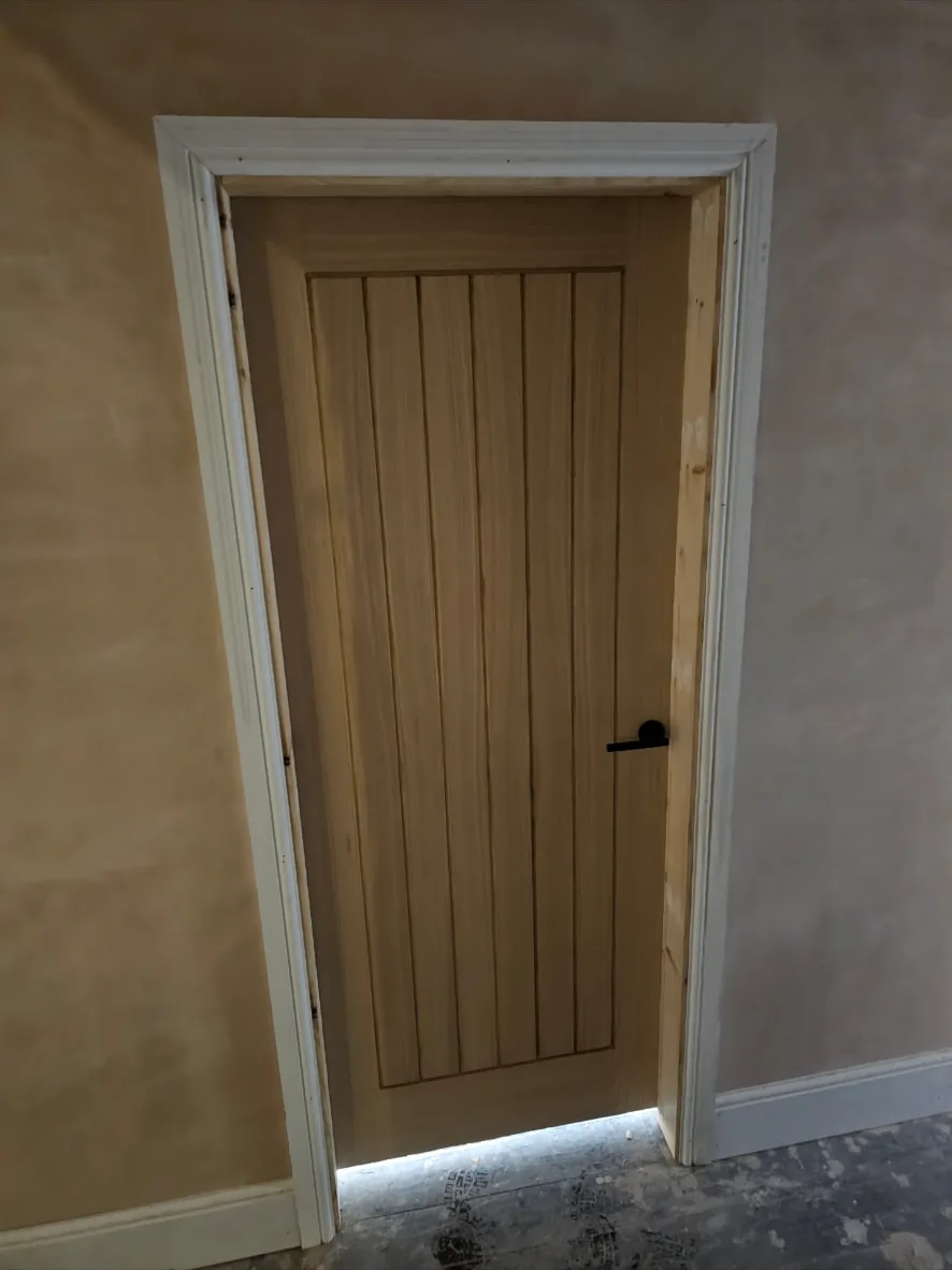 Single oak door hung in a lining with moulded architrave fitted around the opening